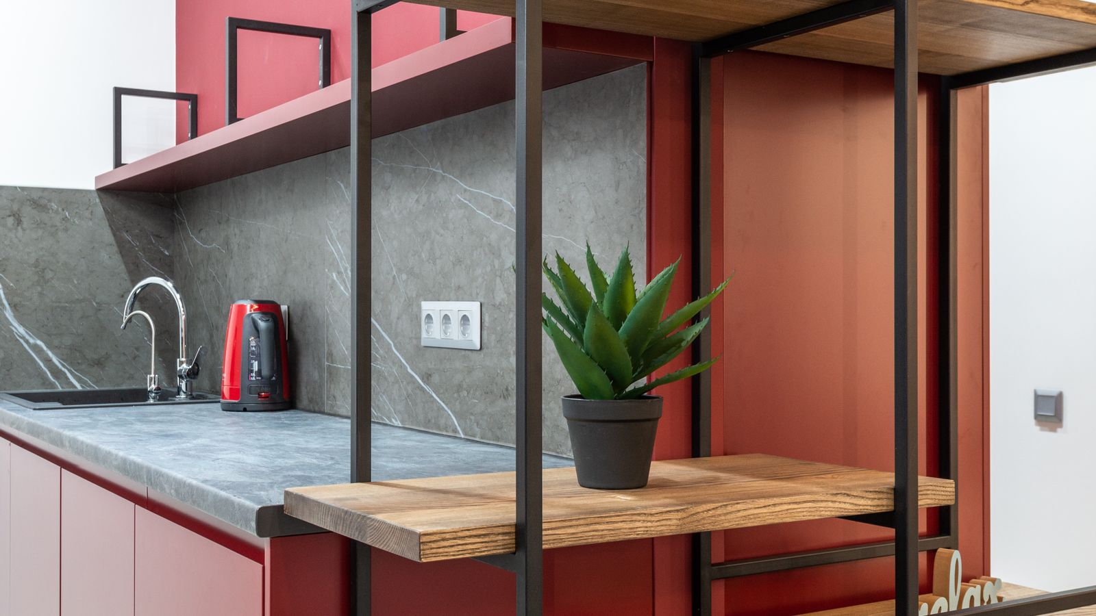 Wooden corner shelf with potted plants and glass jars near a kitchen window