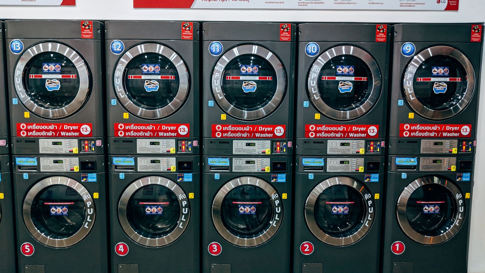 A person checking the level of a stacked washer and dryer unit with a spirit level