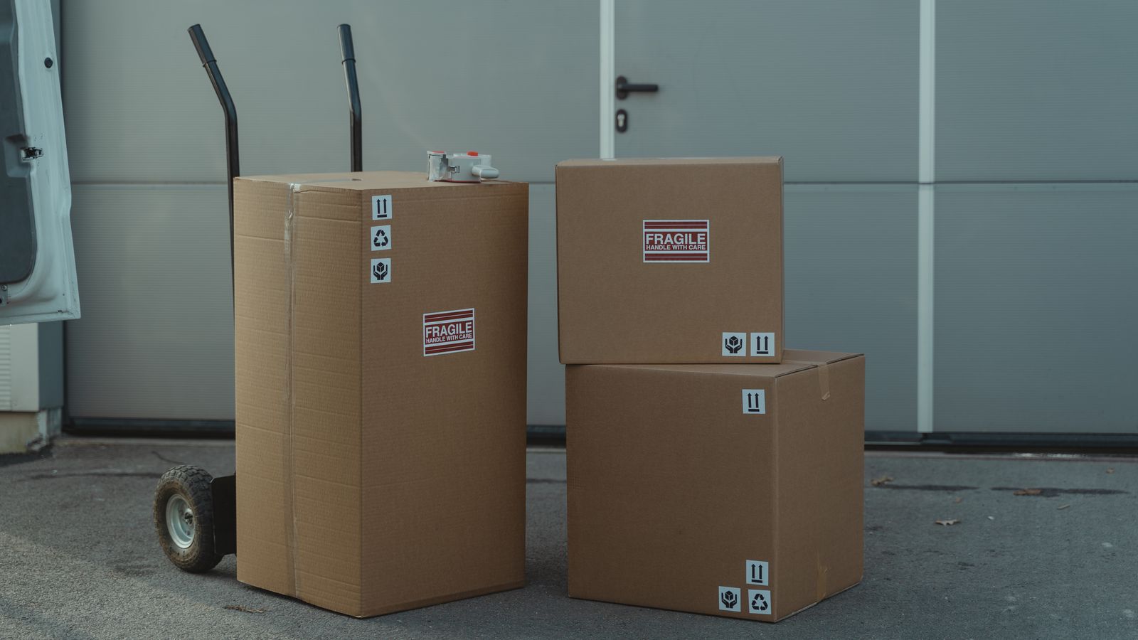 Heavy-duty appliance dolly used to move a large refrigerator across a garage floor