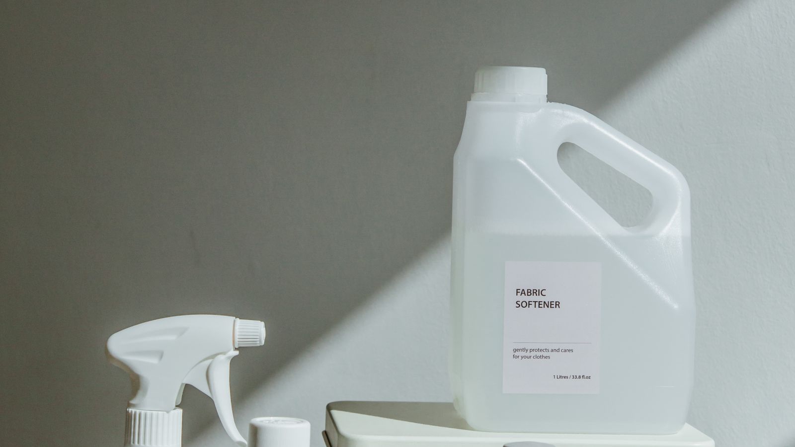 Folded clean laundry stacked beside detergent bottles on a laundry room counter