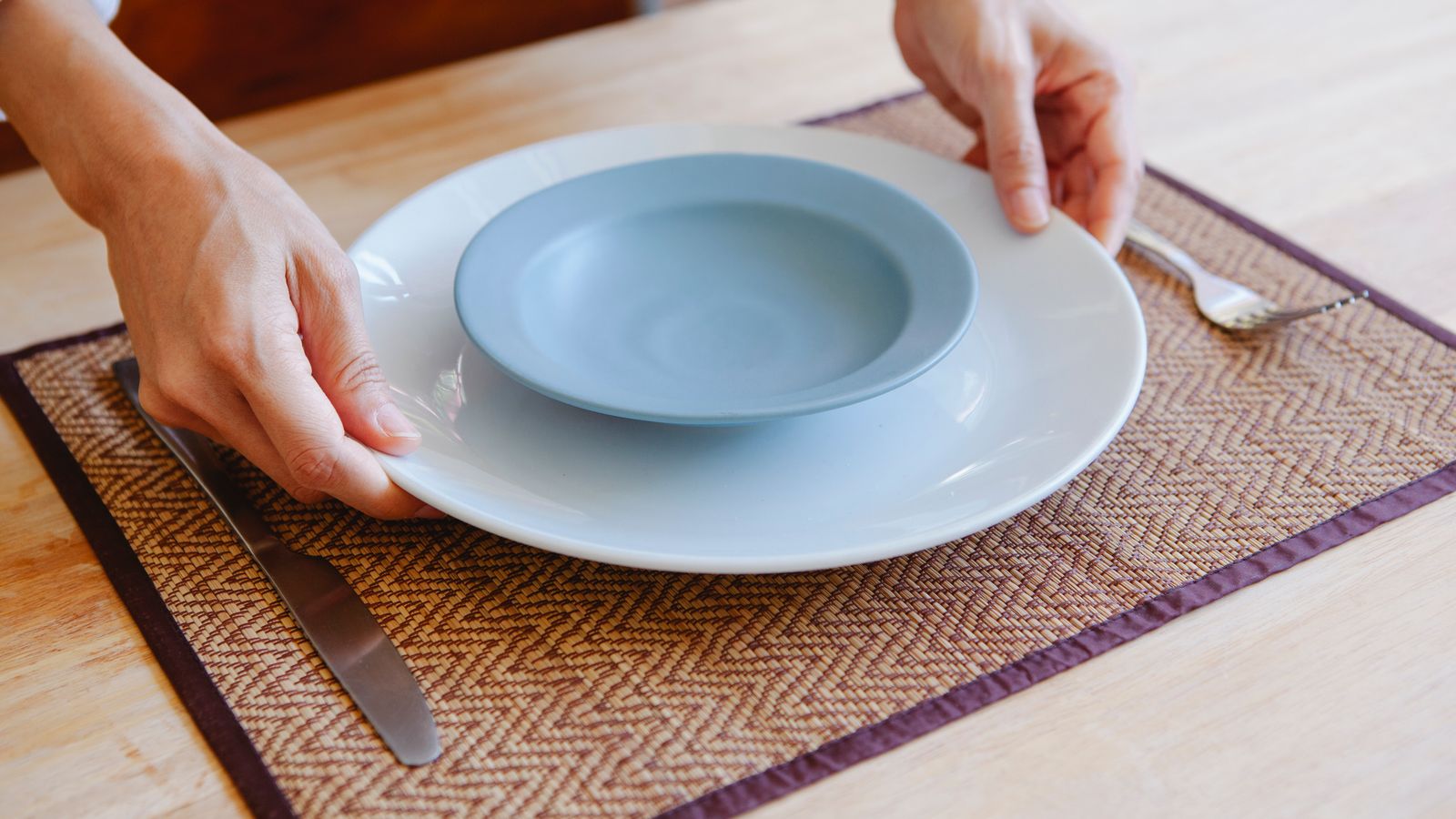 Woven placemats set under ceramic plates on a dining table