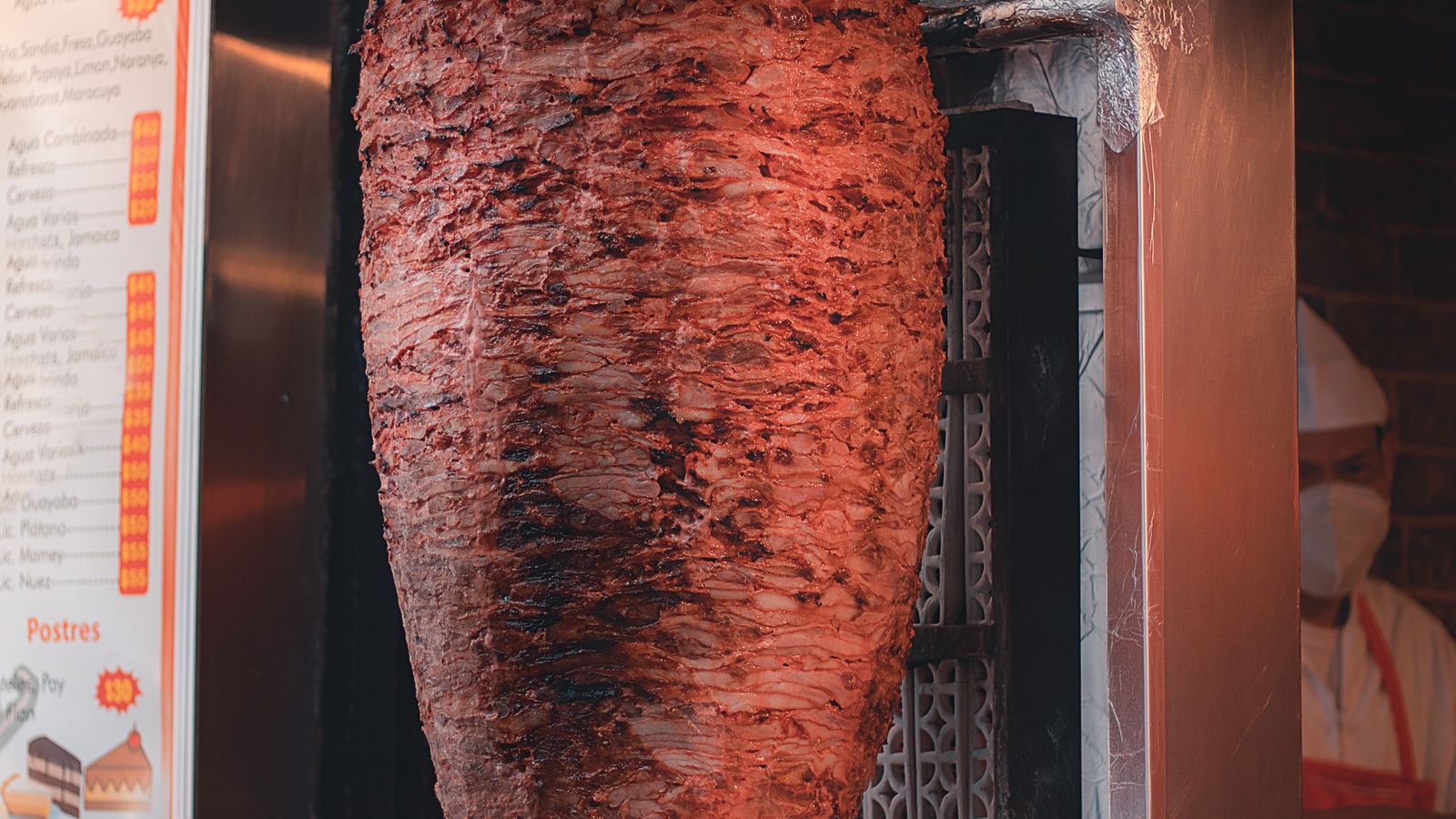Close-up of a rotisserie motor and spit rod mounted on a grill
