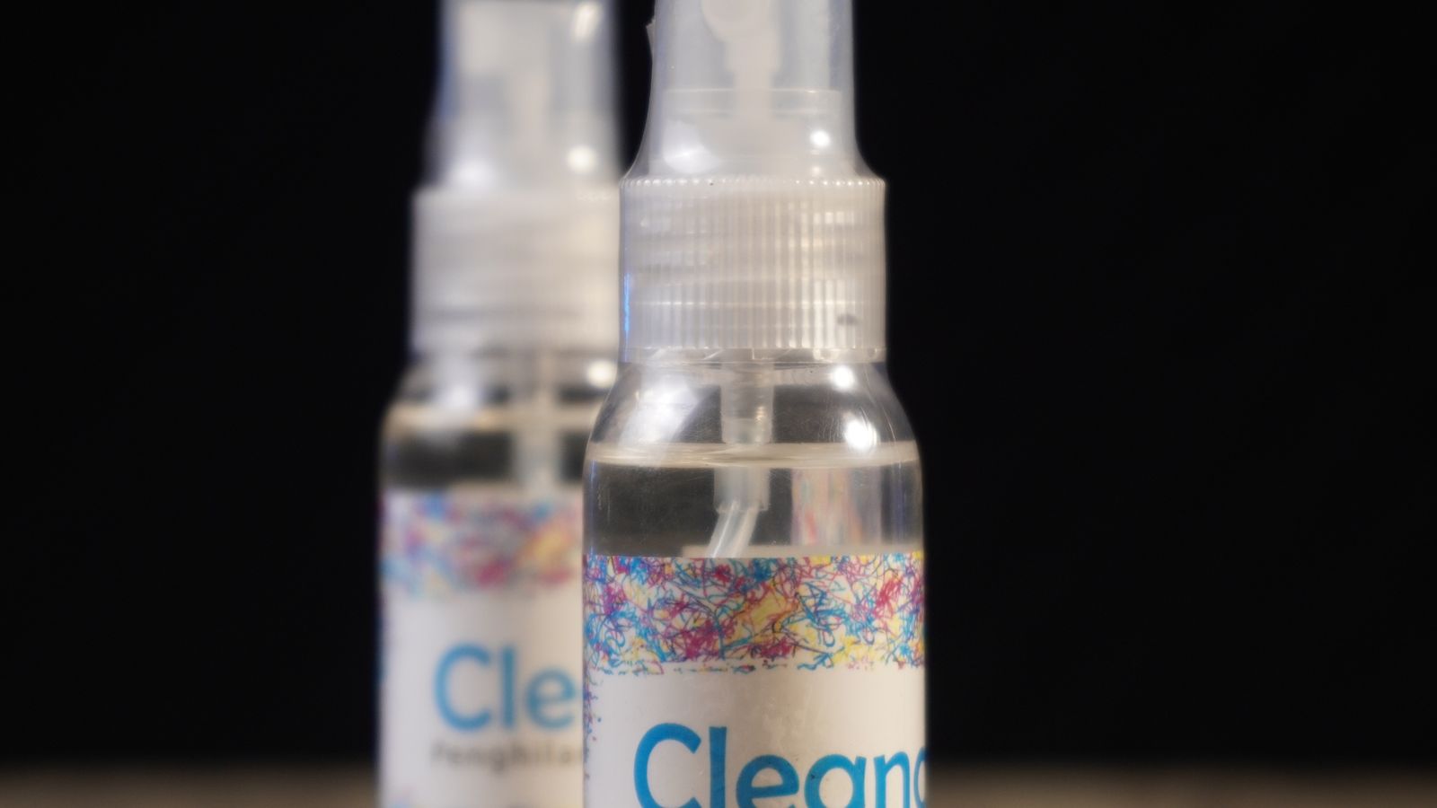 Spray bottles of stain remover lined up on a laundry room shelf
