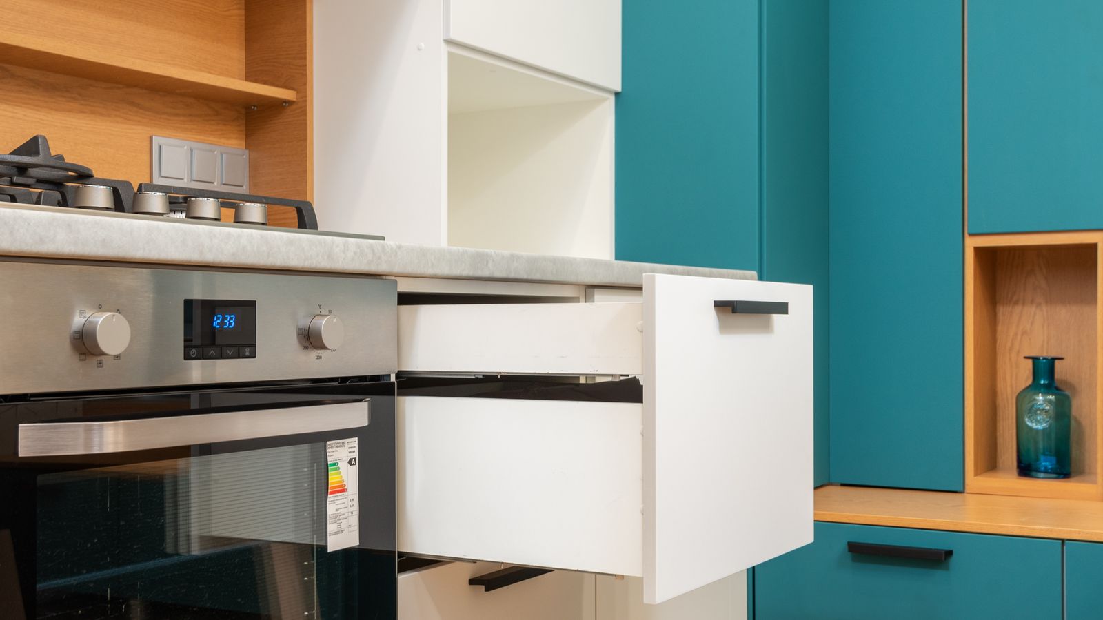 Stacked plates and bowls organized on a two-tier cabinet shelf riser