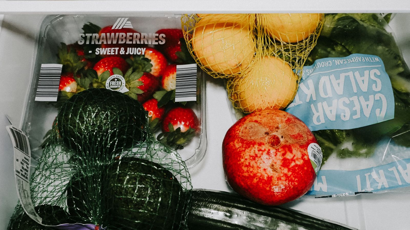 Fresh produce and containers arranged neatly in a refrigerator drawer