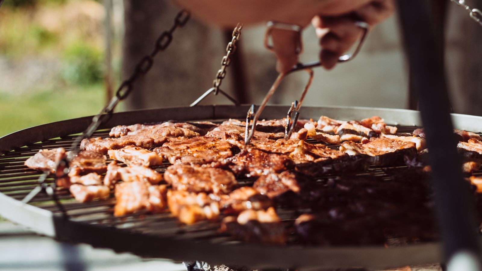 Close-up of steaks searing directly on a grill grate showing char marks