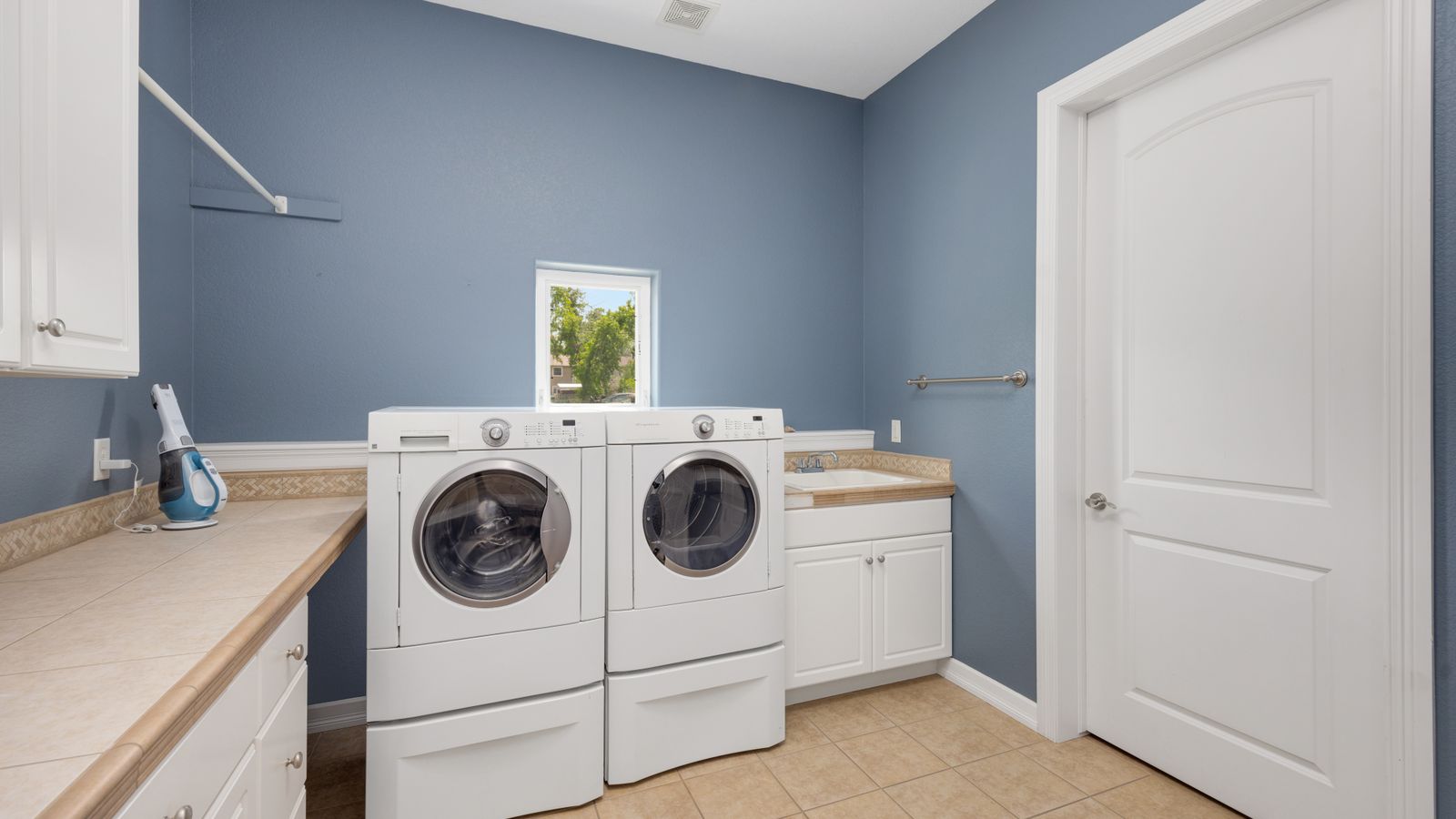 Washing machines with pedestal drawers in a home laundry room setup