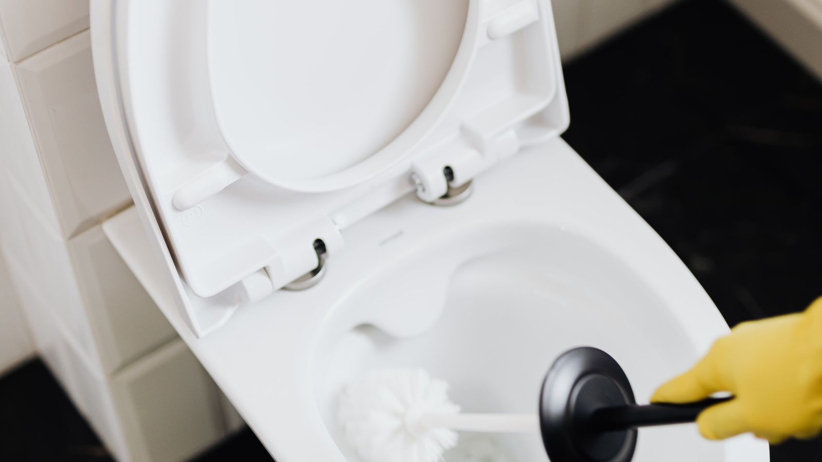 Blue toilet bowl cleaning tablet dissolving in toilet water