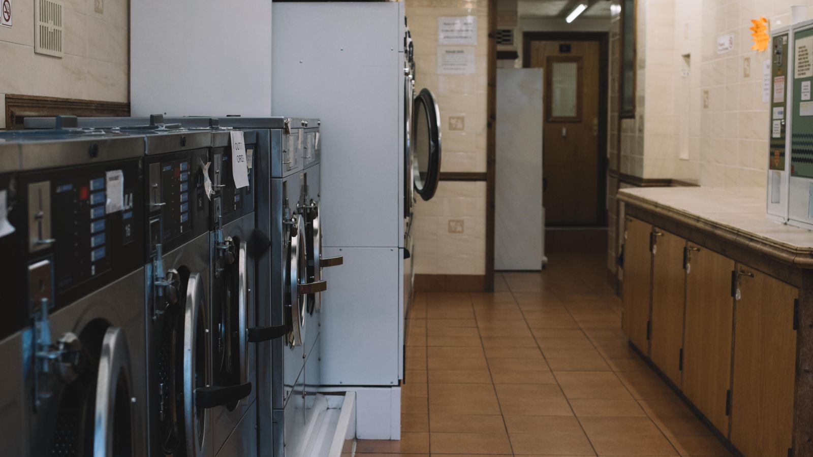 Organized laundry area with a floor mat, hamper, and folded towels arranged neatly