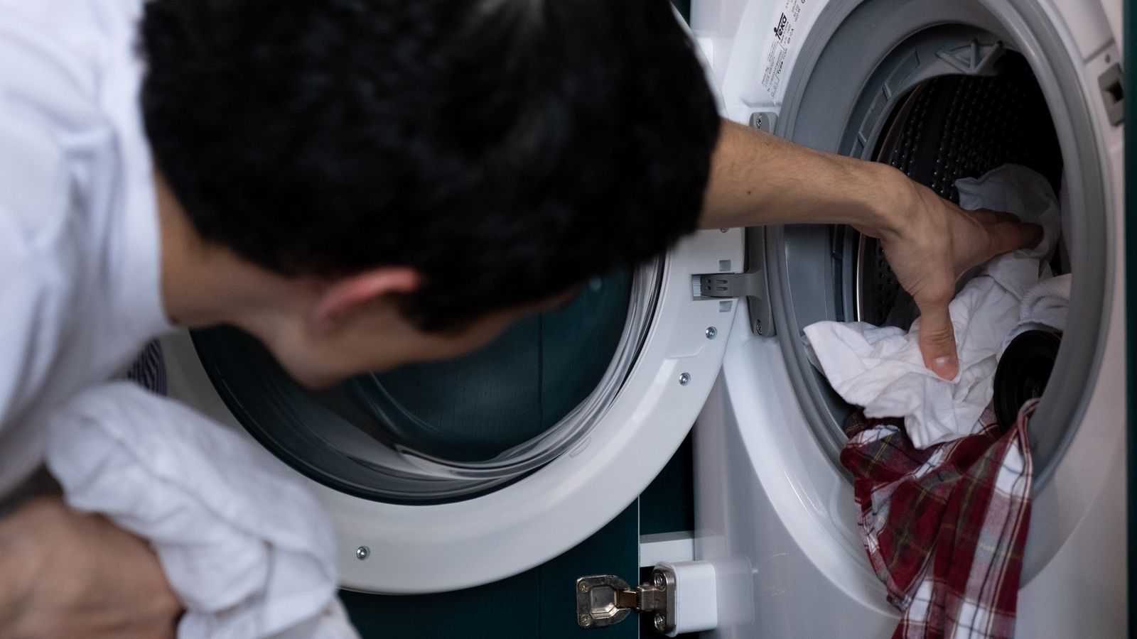 Neatly organized home laundry room with folded towels and drying accessories