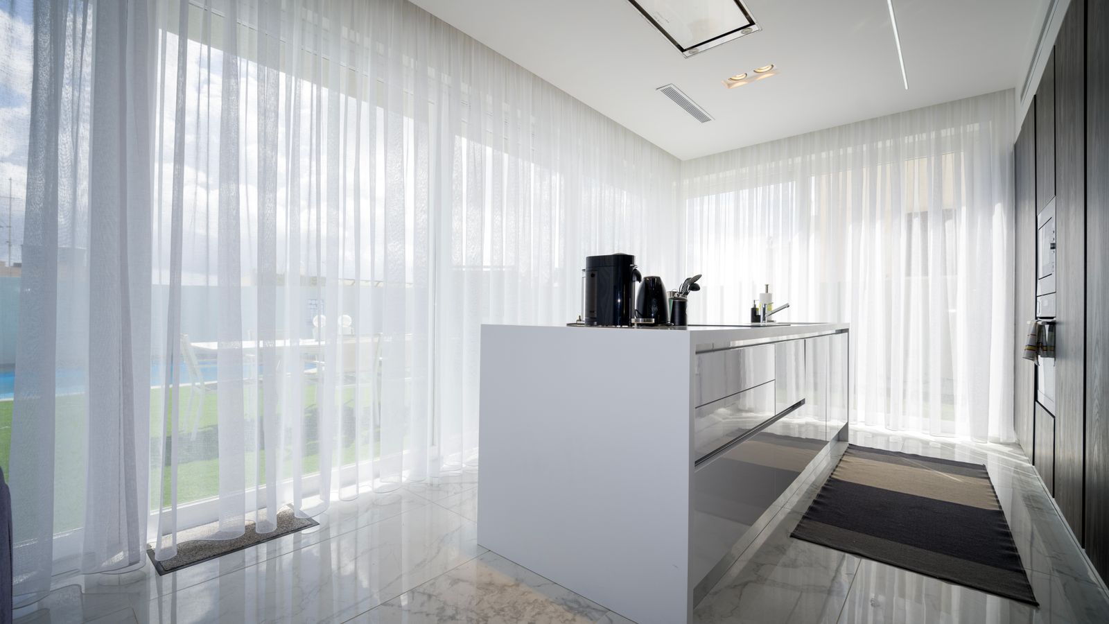 Bright kitchen window dressed with sheer curtains letting in natural light
