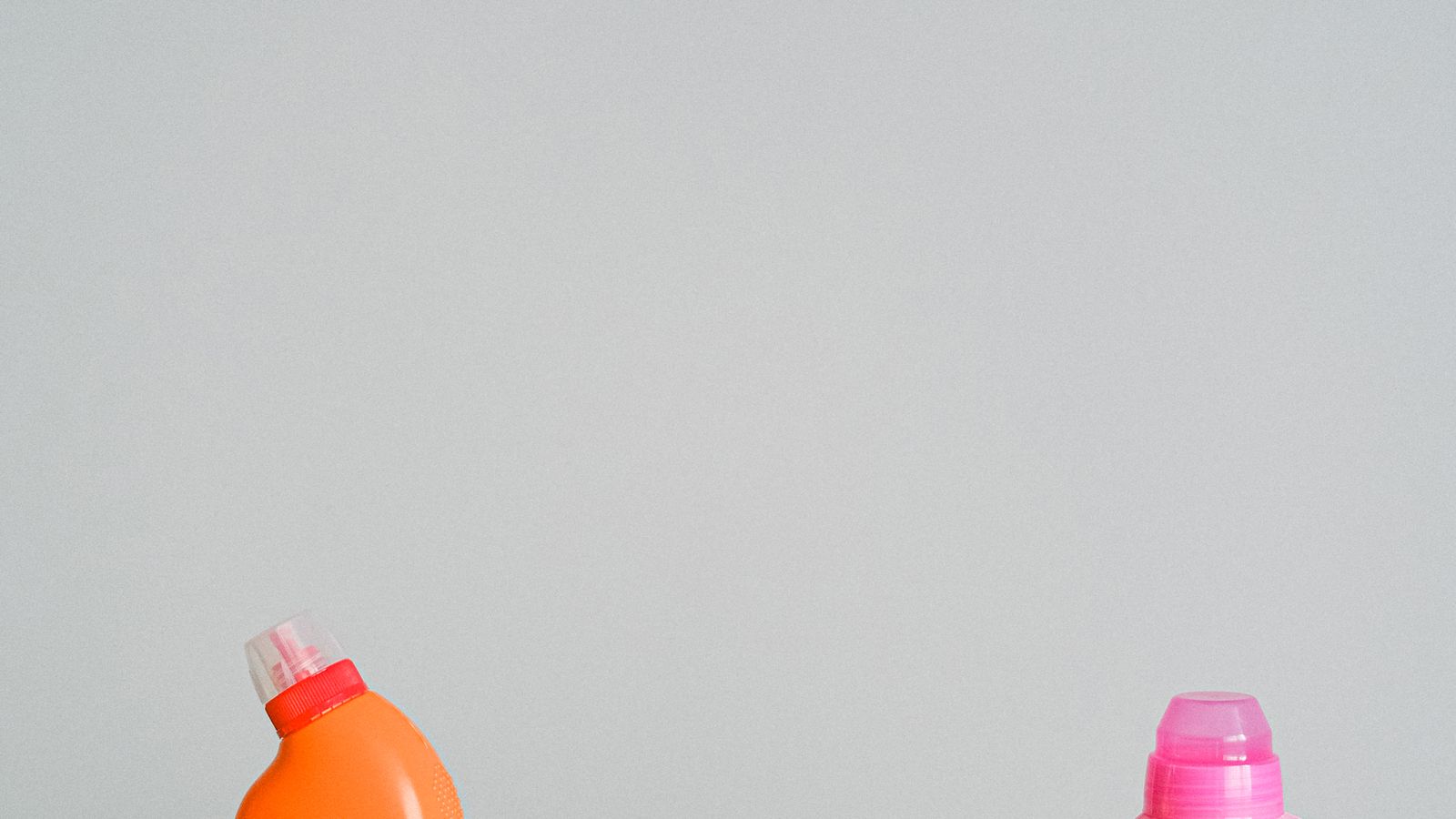 Assorted colorful cleaning product bottles arranged together on a shelf
