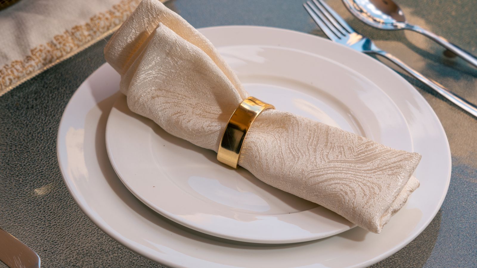 Elegant table setting with rolled napkin, napkin ring, and placemat arranged for a formal dinner