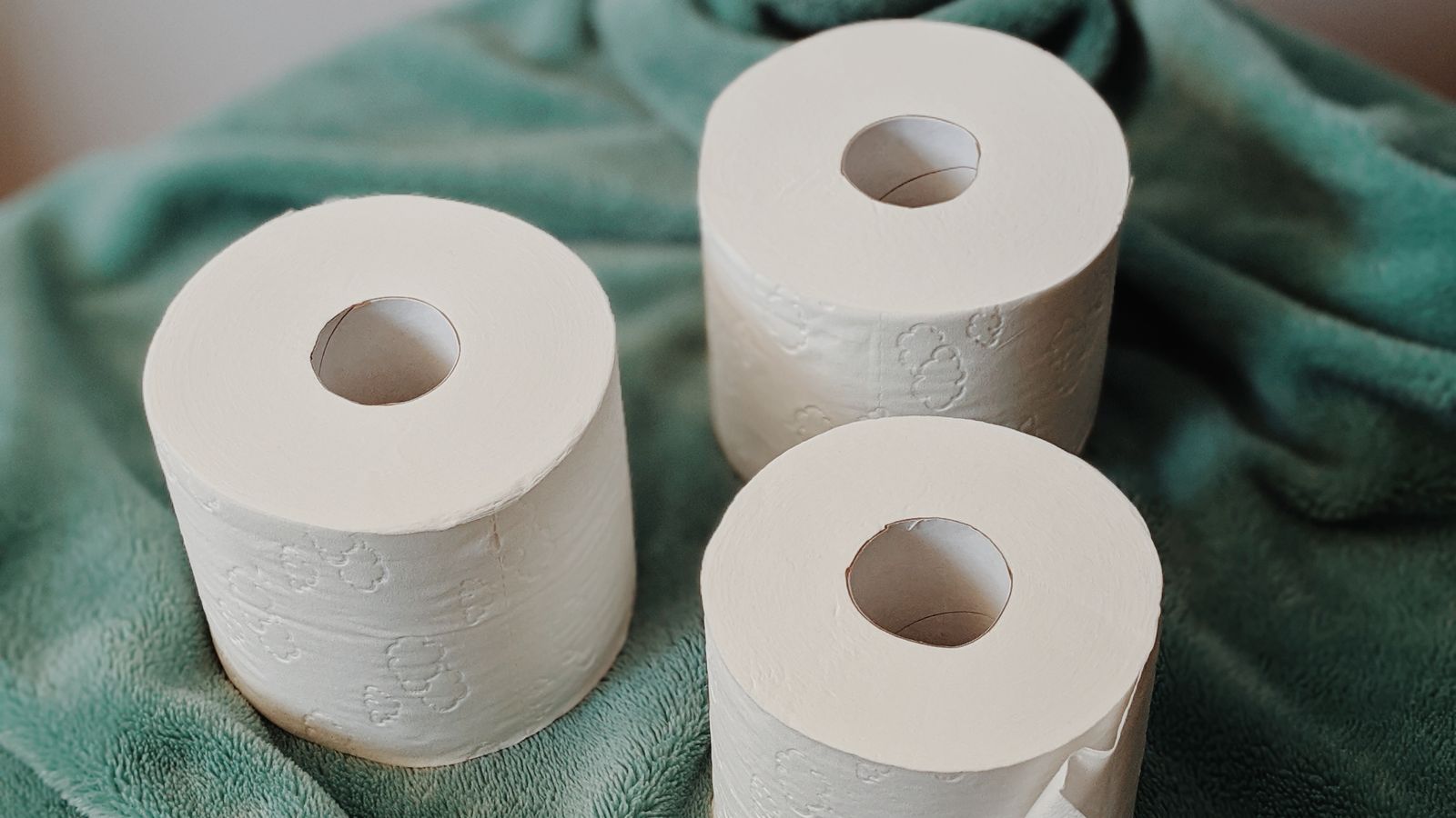 Roll of paper towels standing upright on a kitchen counter next to cleaning supplies