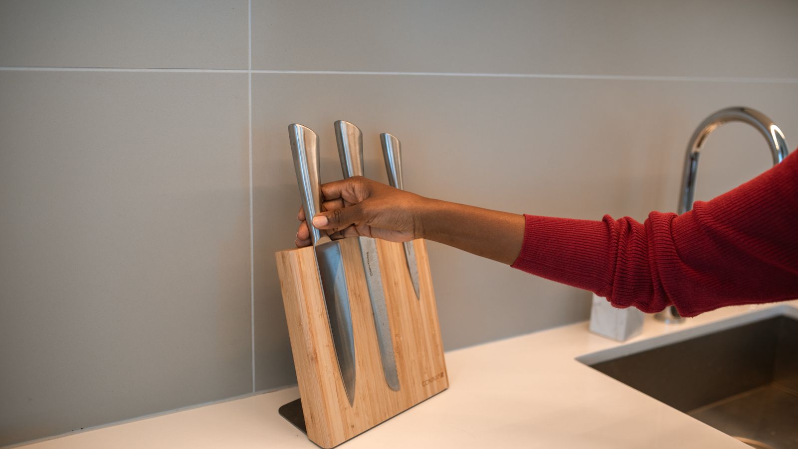 Wooden countertop knife block with knives being removed for cleaning