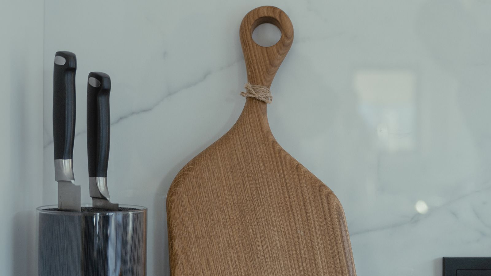 Close-up of cleaning inside a wooden knife block slot with a brush