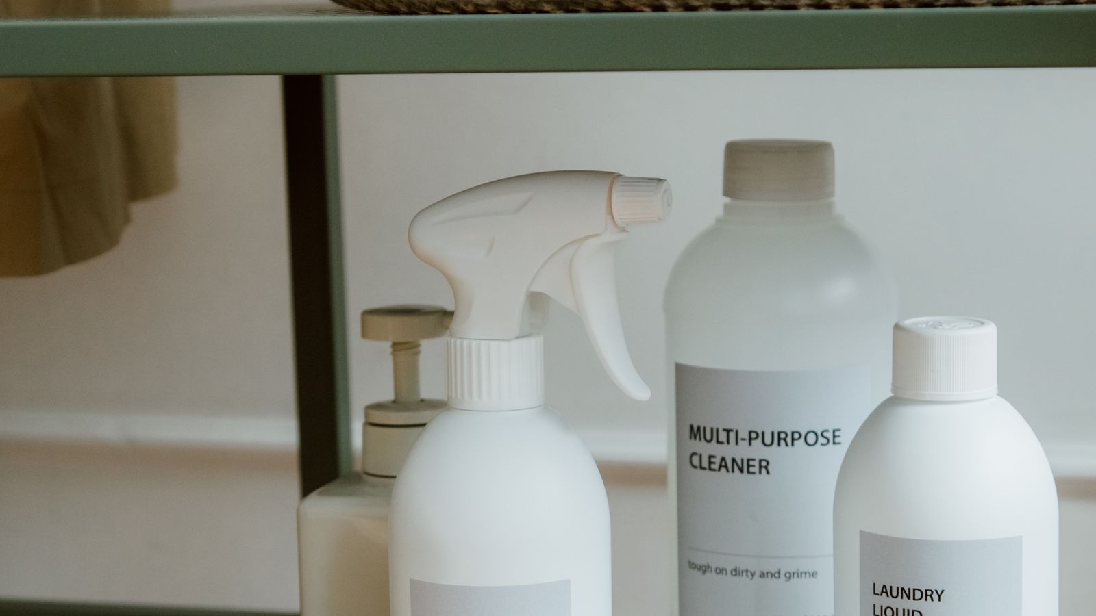 Neatly organized cleaning supplies on a shelf inside a downsized cabinet