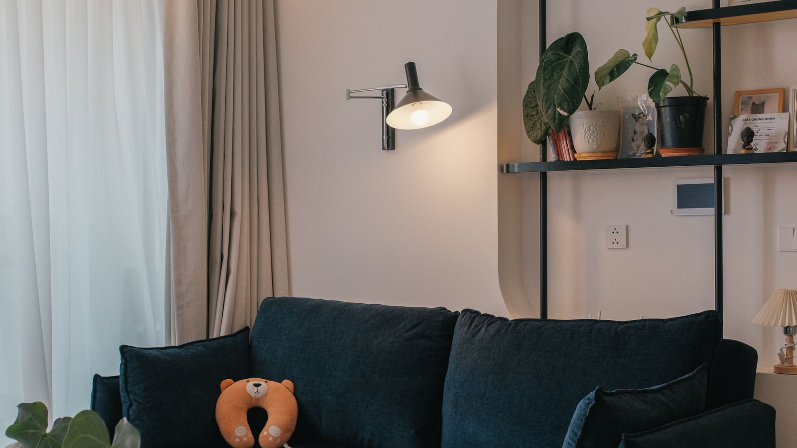 Living room with a navy sofa, layered textures, and indoor plants illustrating texture mixing in home decor
