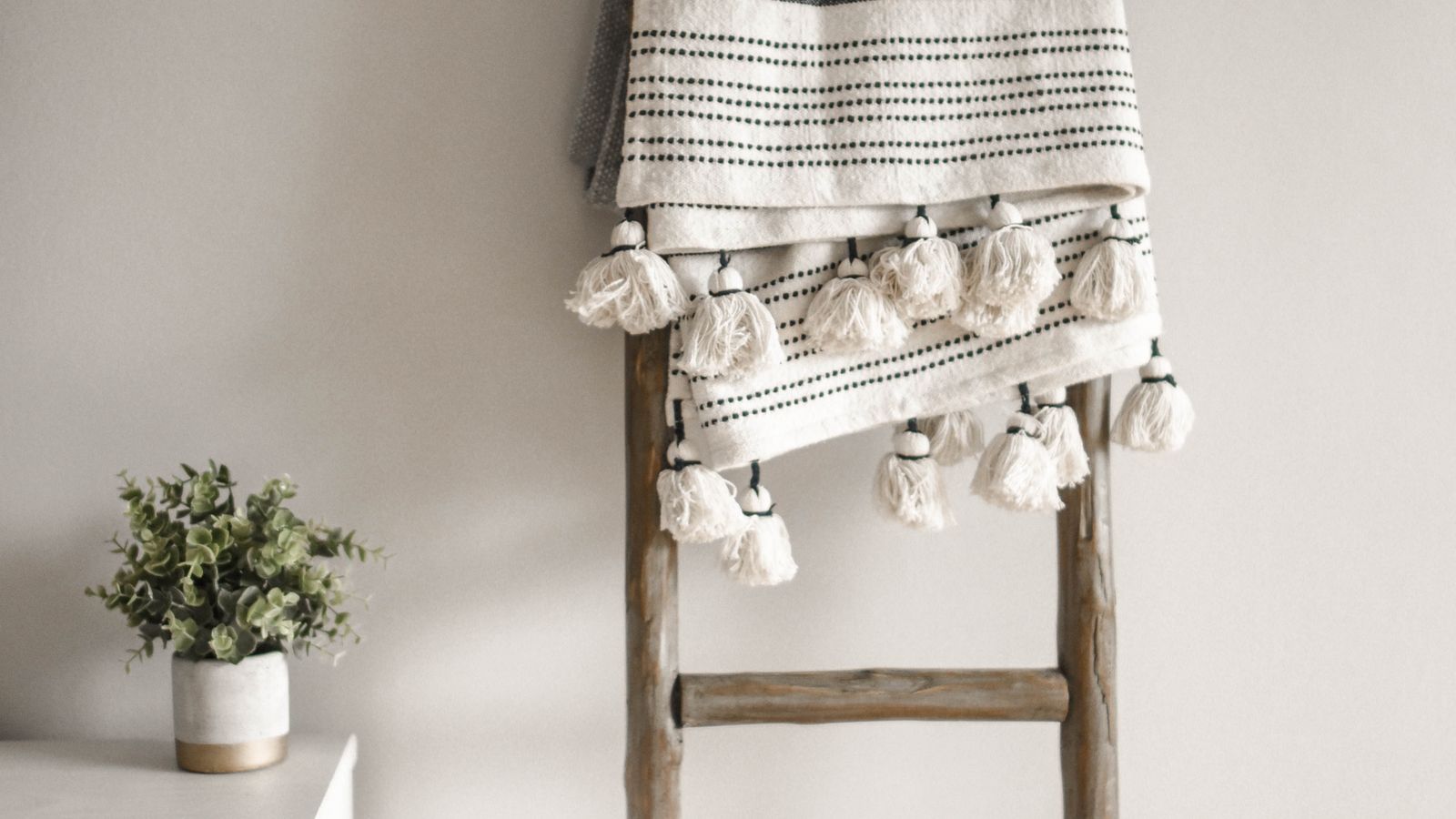 Decorative ladder with a folded throw blanket styled as a home decor accent