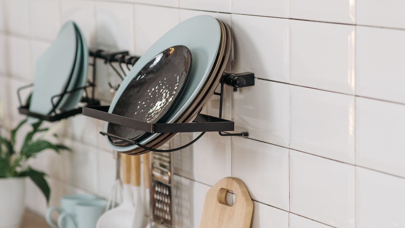 Under-cabinet storage basket mounted beneath kitchen cabinets holding fresh produce