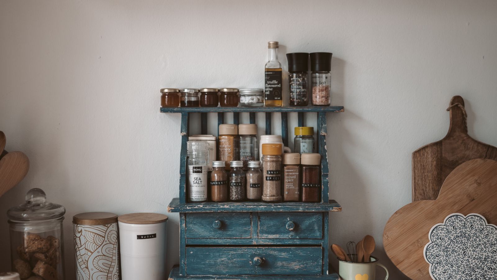Neatly arranged spice jars and kitchen tools on a wooden countertop