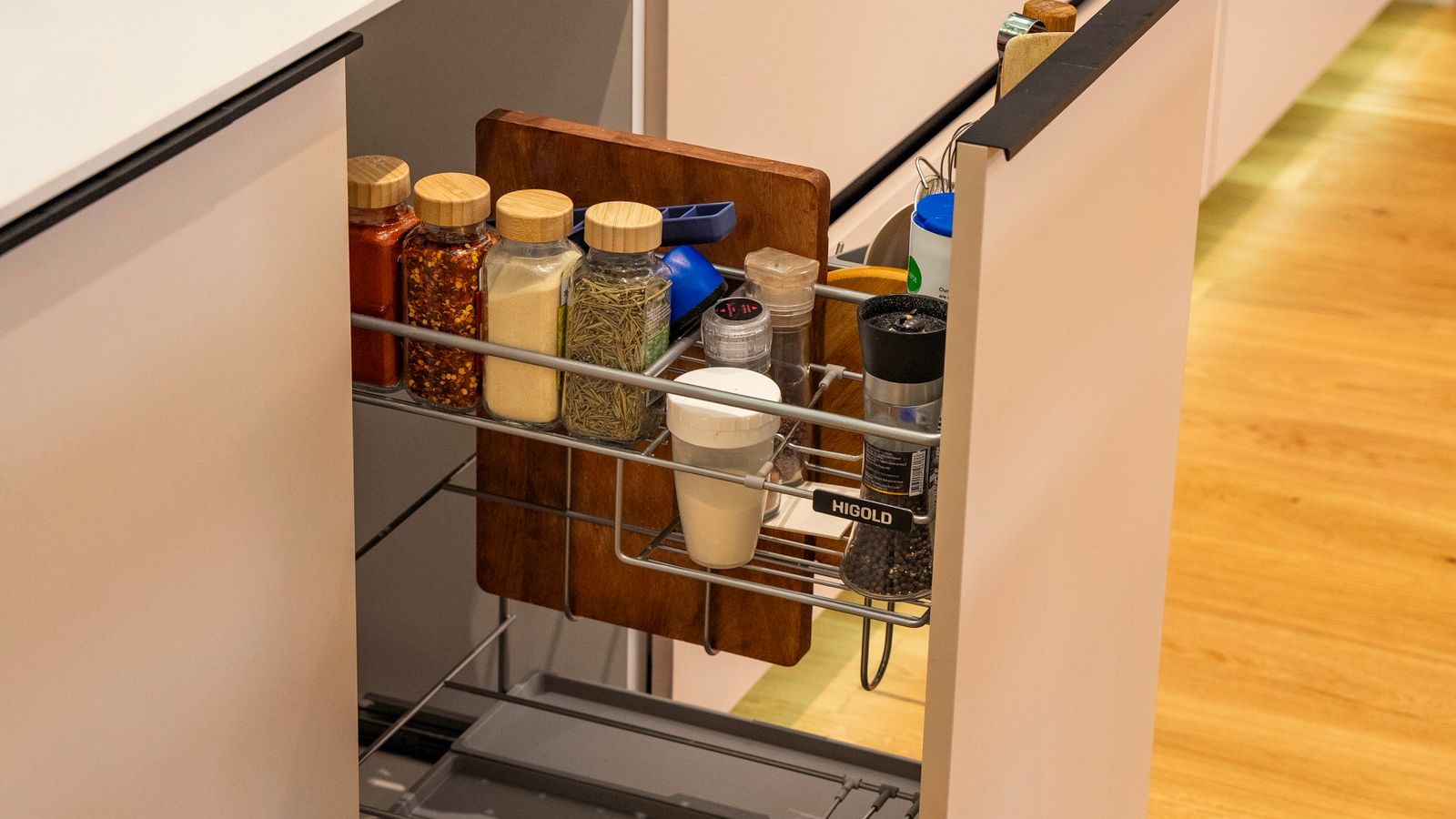 Magnetic spice tins arranged on a metal strip in a kitchen