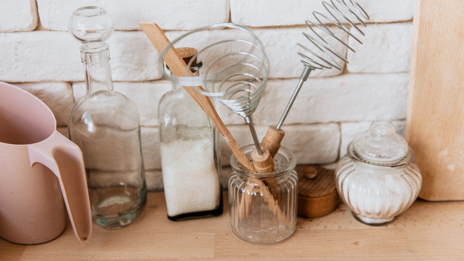 Kitchen utensil holder filled with cooking tools next to a stovetop