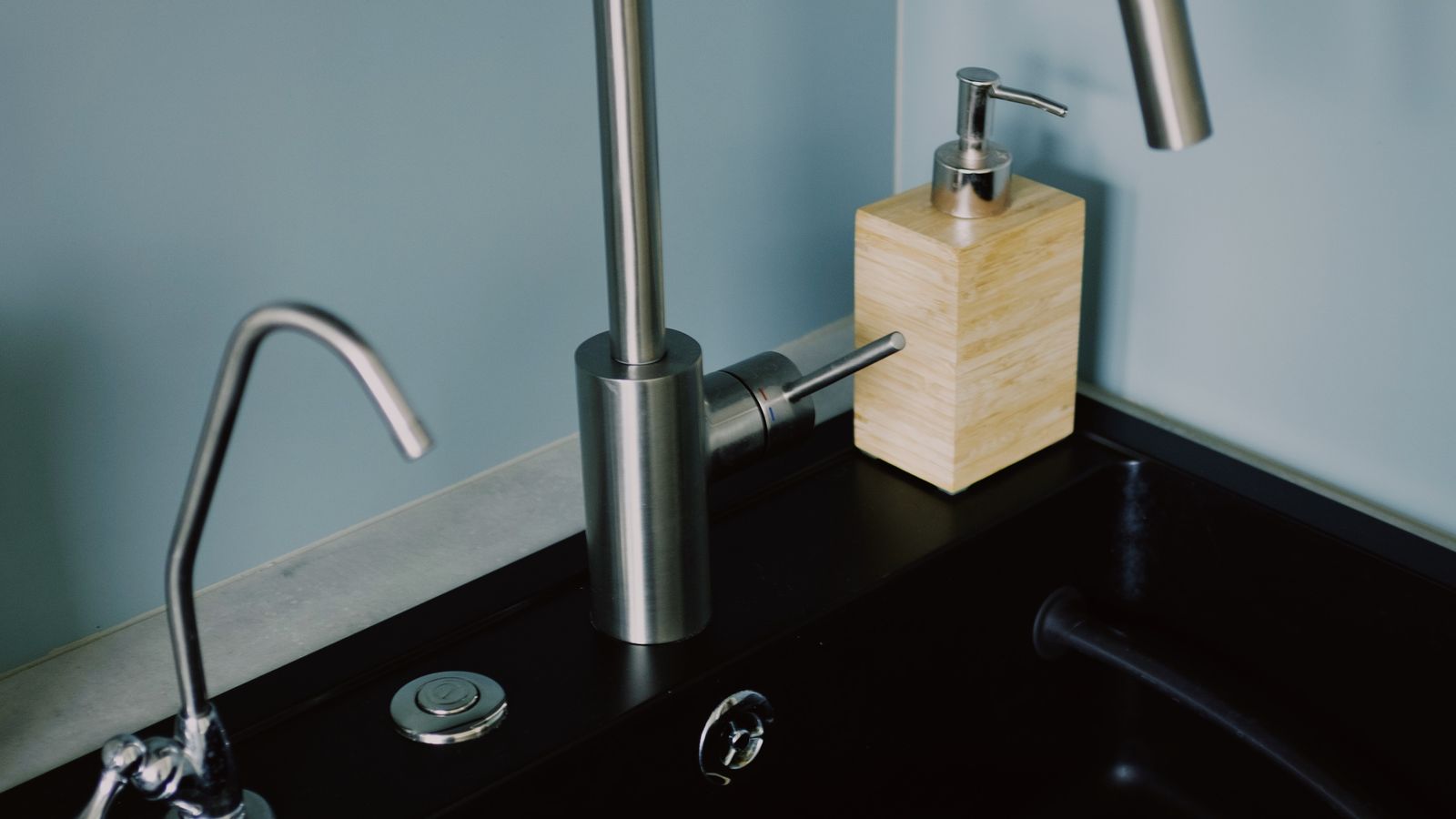 Modern kitchen faucet near a countertop hot water dispenser setup