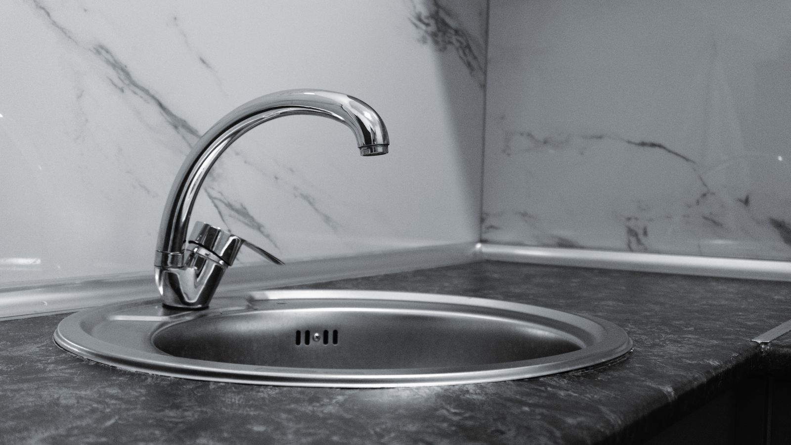 Modern stainless steel pot filler faucet mounted above a kitchen range