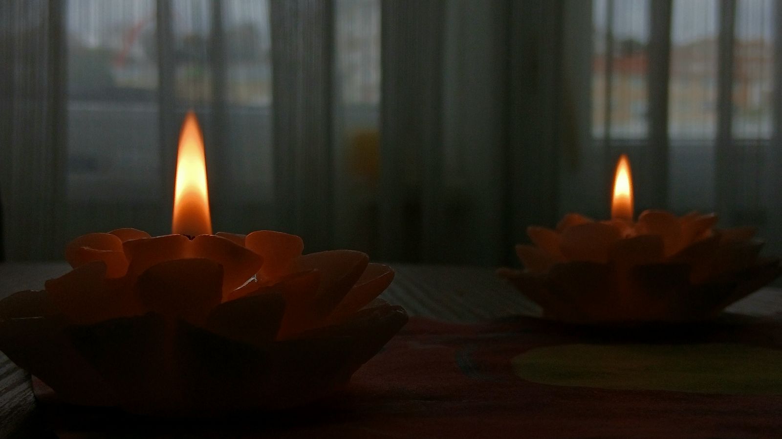 Assorted candles in glass and ceramic holders arranged on a wooden table