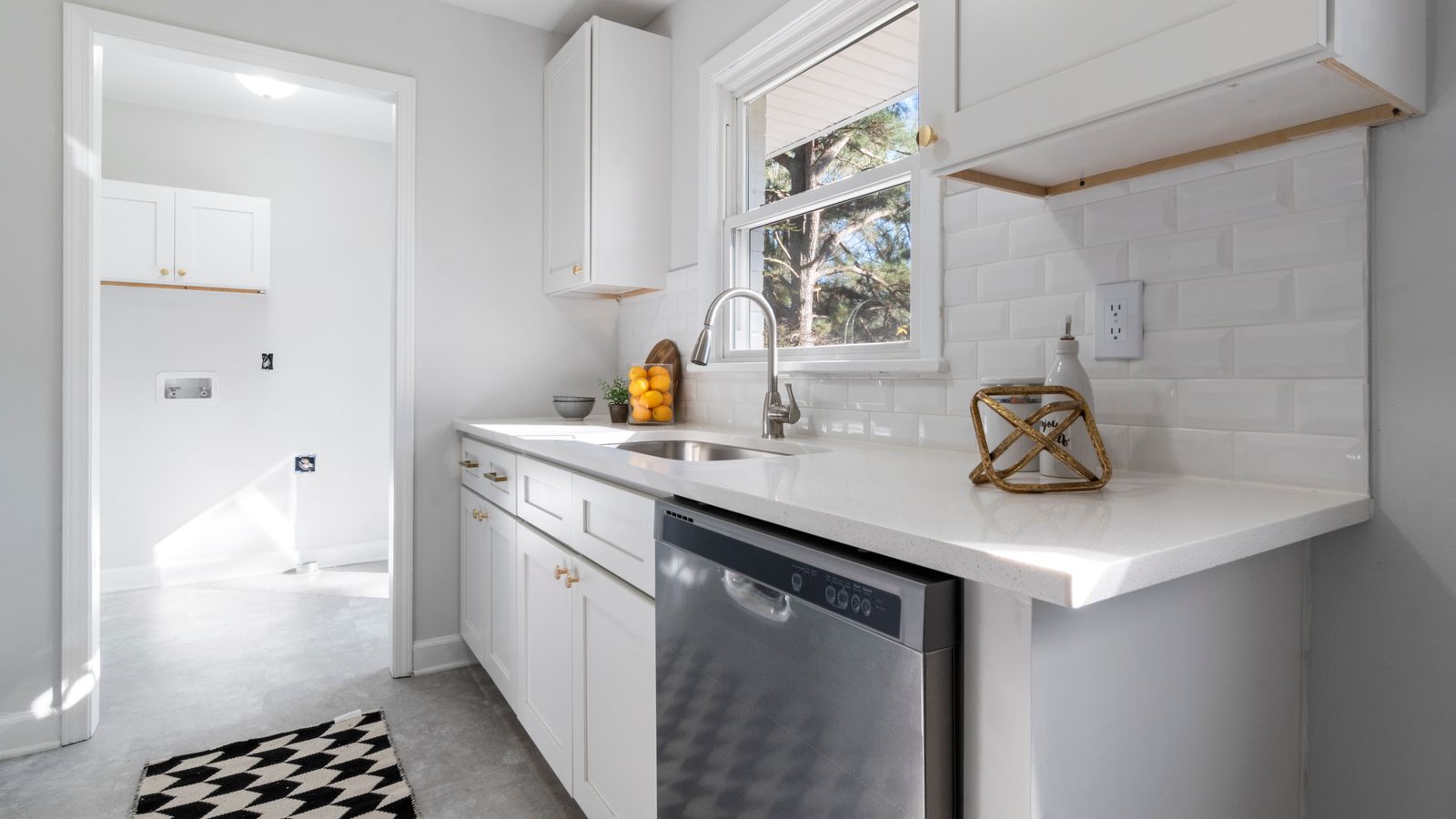 Kitchen sink front mat placed on a tiled floor near a farmhouse sink