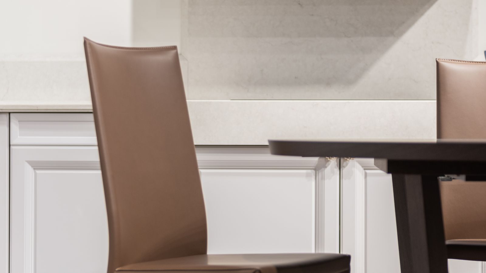 Area rug under a wooden dining table in a kitchen with brown chairs