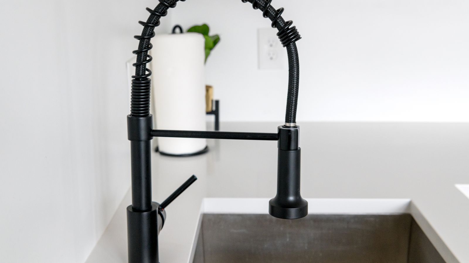 Stainless steel undermount kitchen sink installed beneath a granite countertop