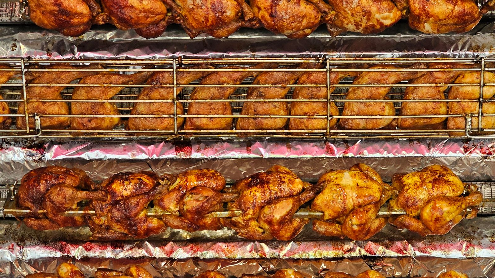 Golden rotisserie chicken turning on a spit in a countertop rotisserie oven