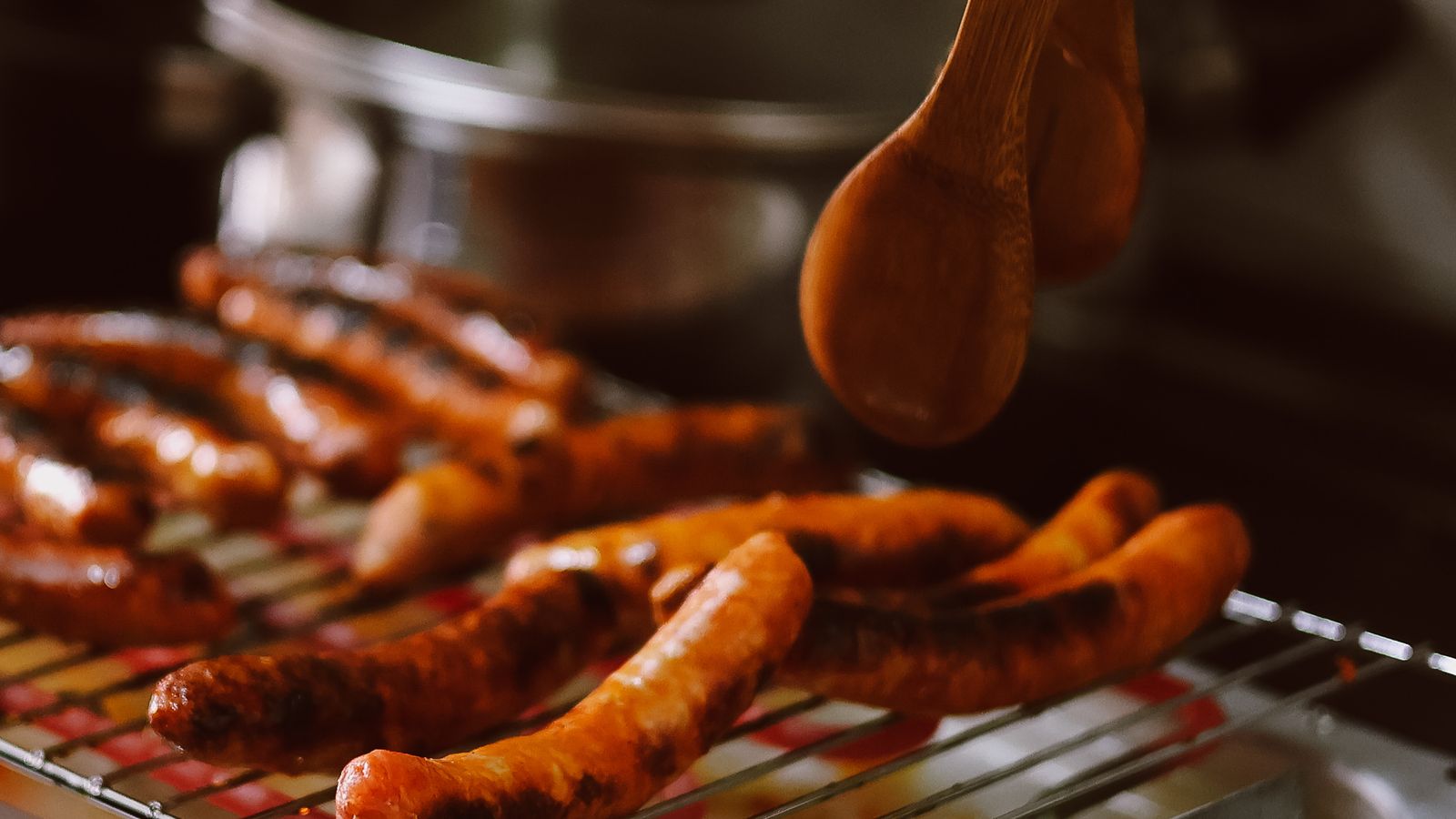 Sausages sizzling on an indoor electric grill on a kitchen countertop