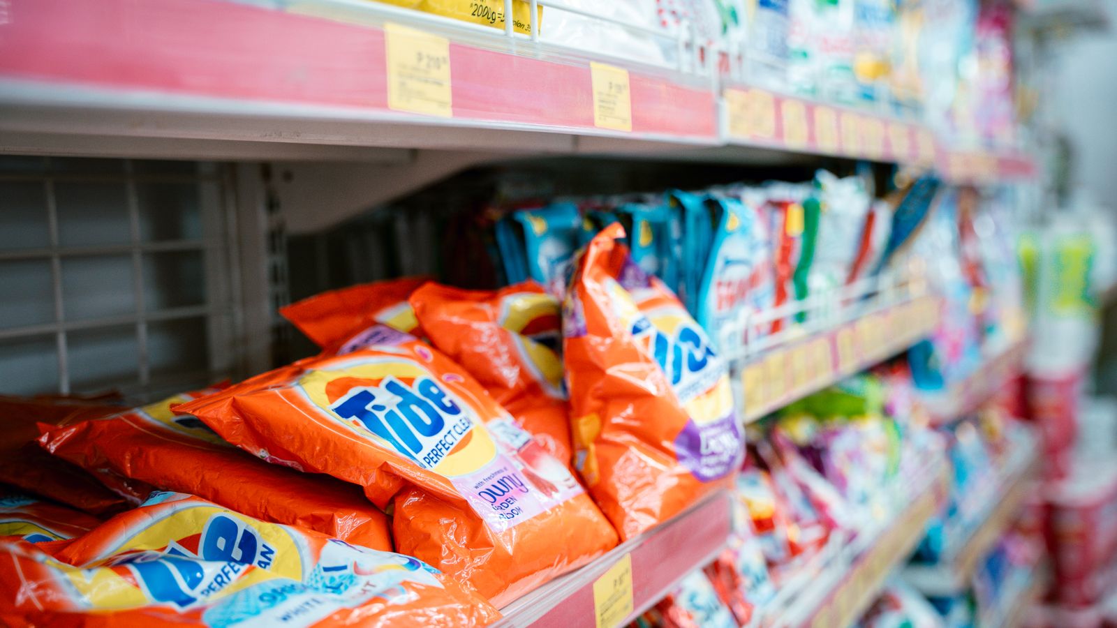 Assorted laundry detergent bottles arranged on a store shelf by category