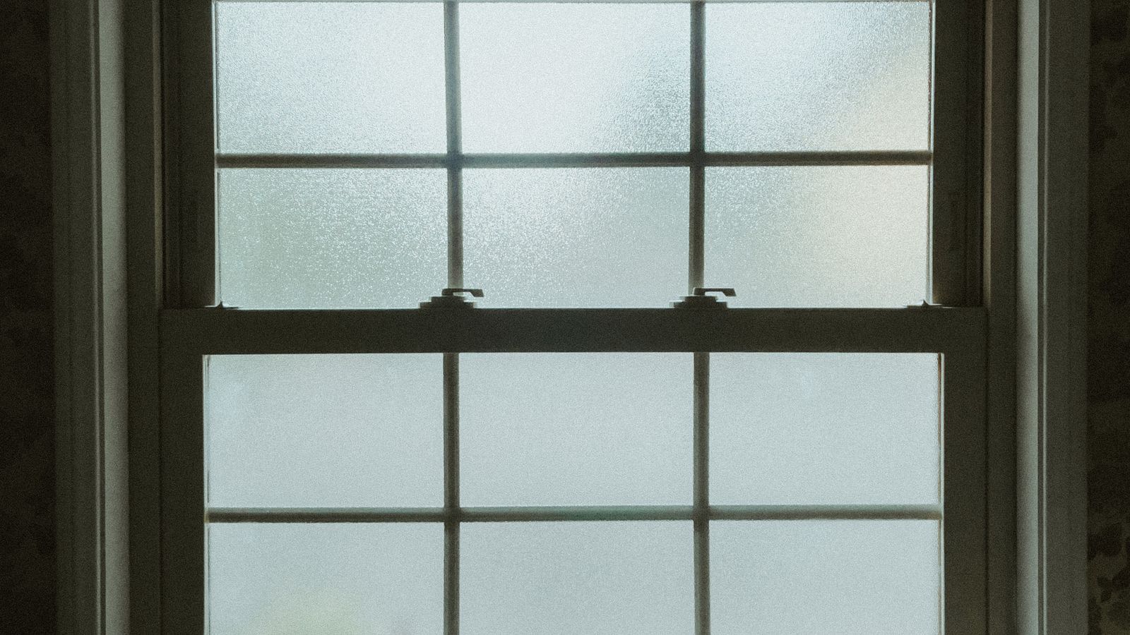 Frosted window film applied to a small bathroom window letting in soft diffused light