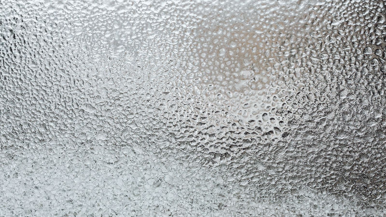 Small bathroom window with frosted film paired with a simple café curtain below