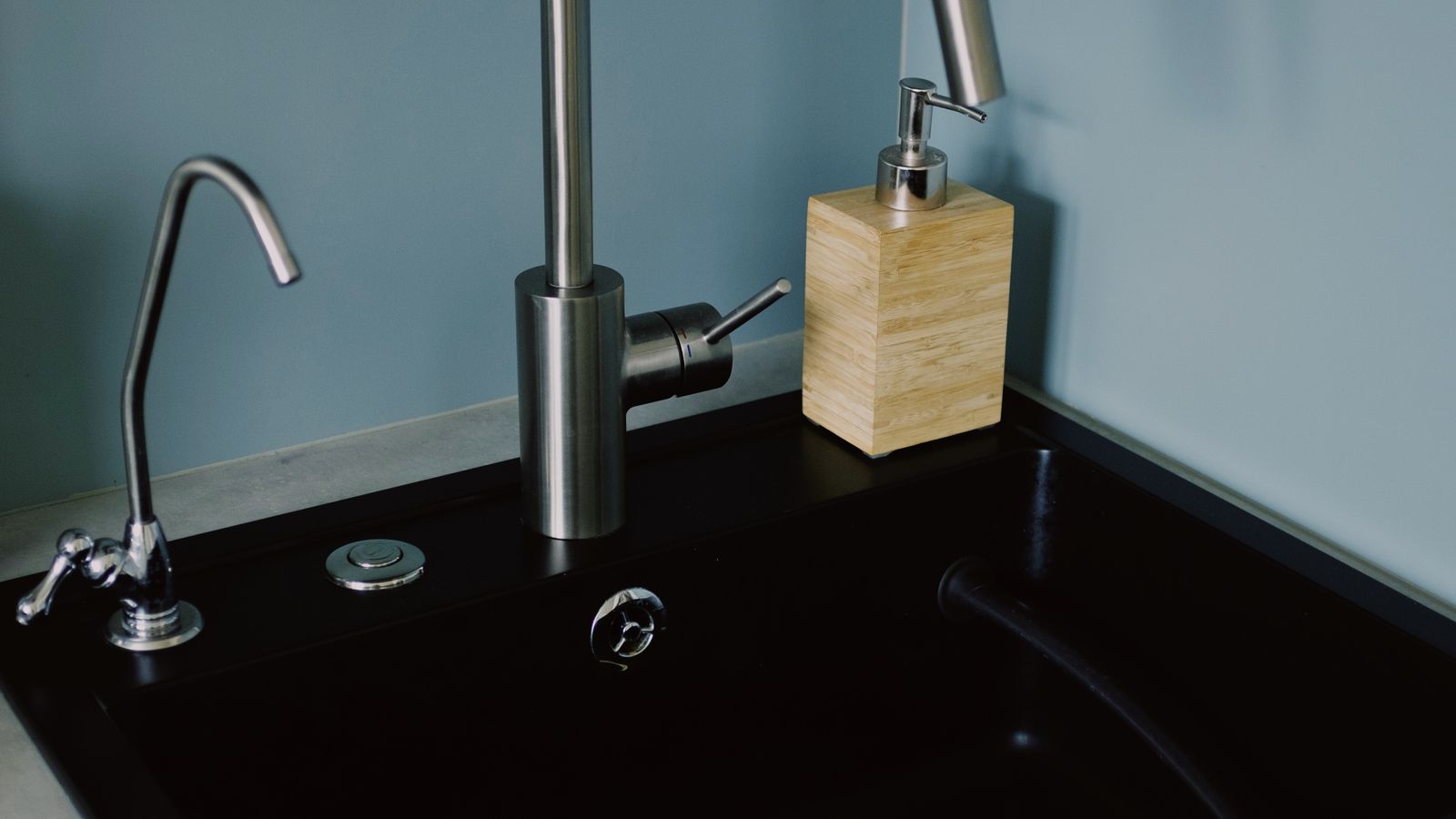 Compact instant hot water dispenser faucet installed beside a kitchen sink