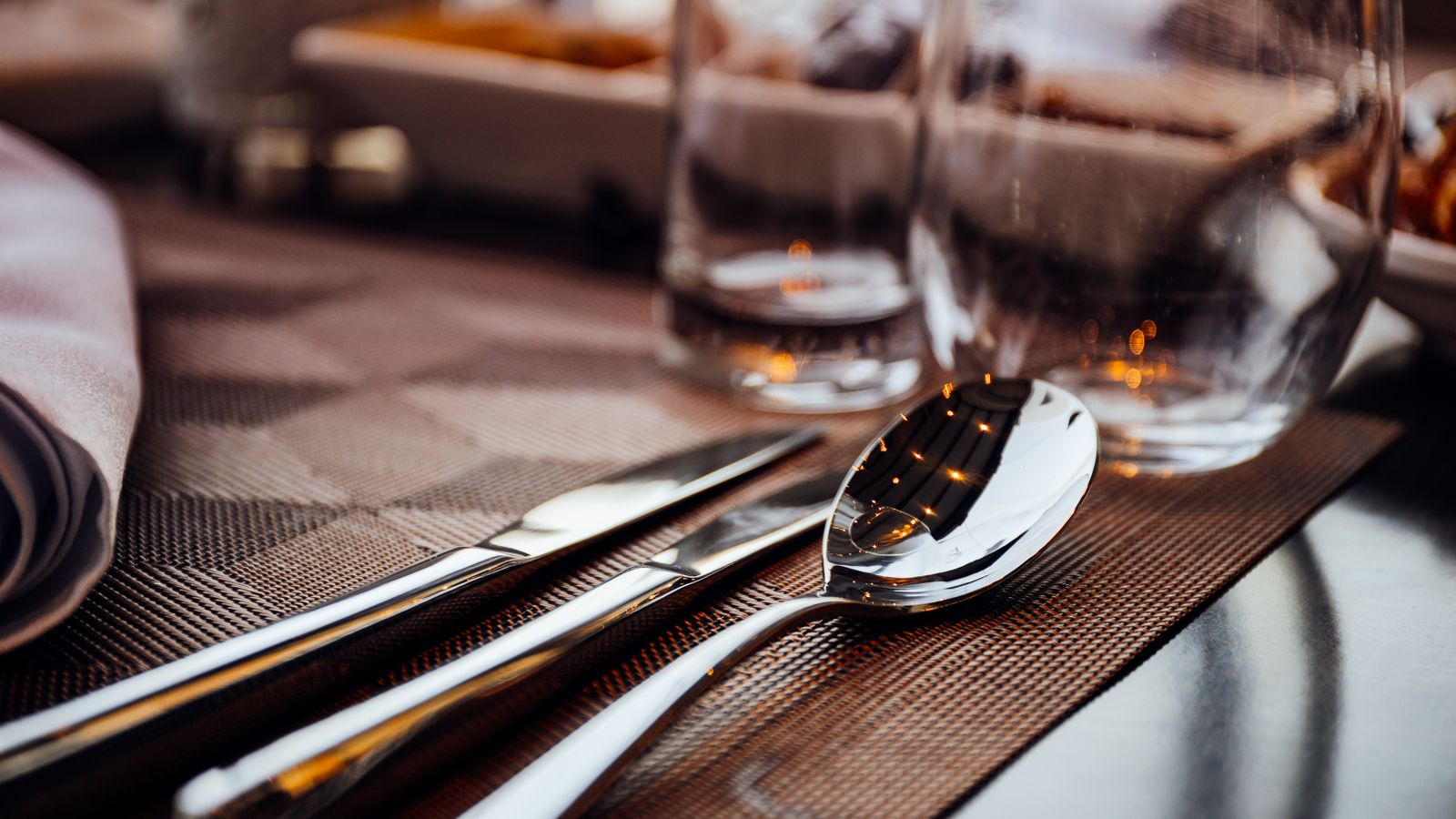 Woven placemats set on a compact table with plates and glasses