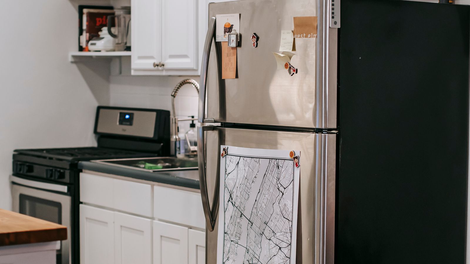 Person organizing groceries inside a compact refrigerator in a small kitchen