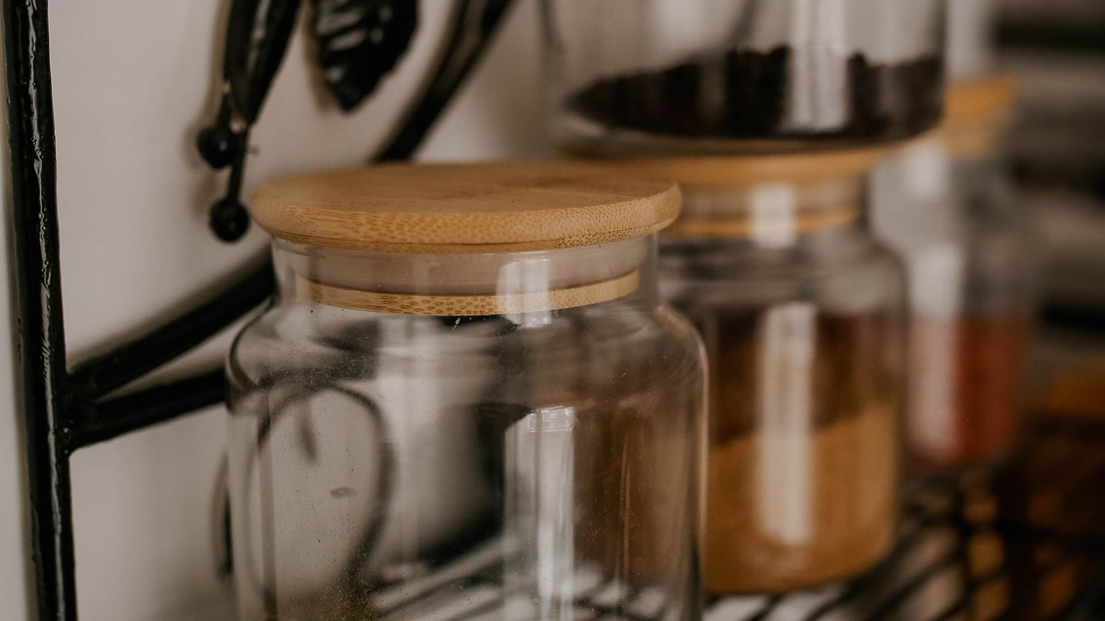 Rows of labeled spice jars organized on a kitchen shelf near the stove
