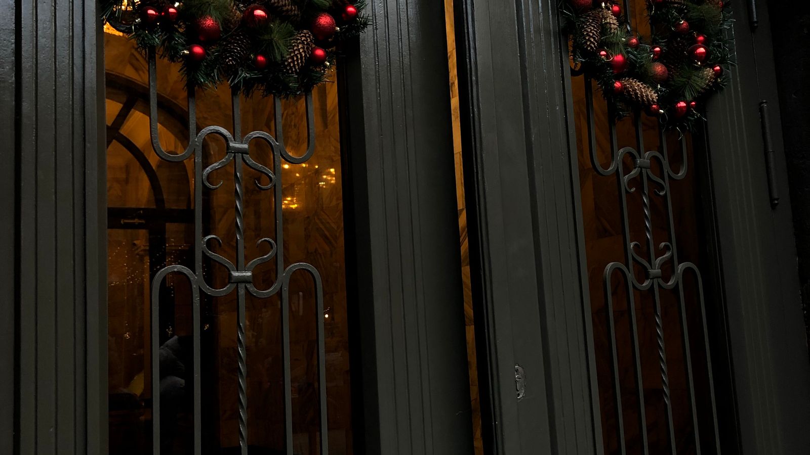 A decorative wreath hanging on a front door as part of a home decor scheme