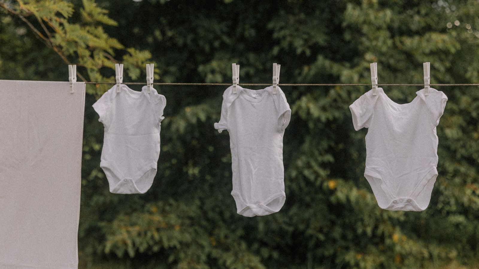 Freshly washed baby clothes hanging to dry on a clothesline