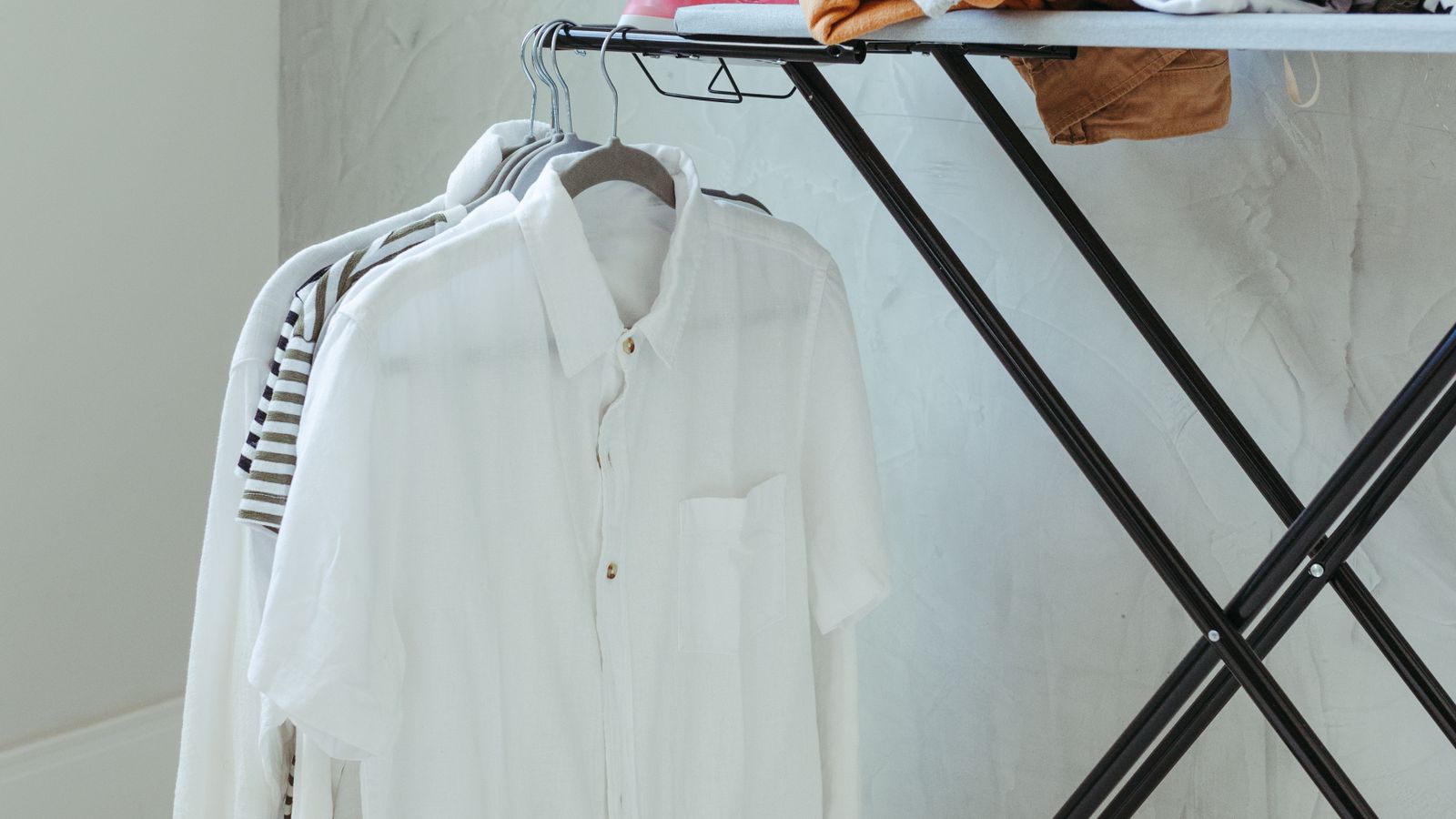 Compact ironing and steamer board set up in a bright home laundry room