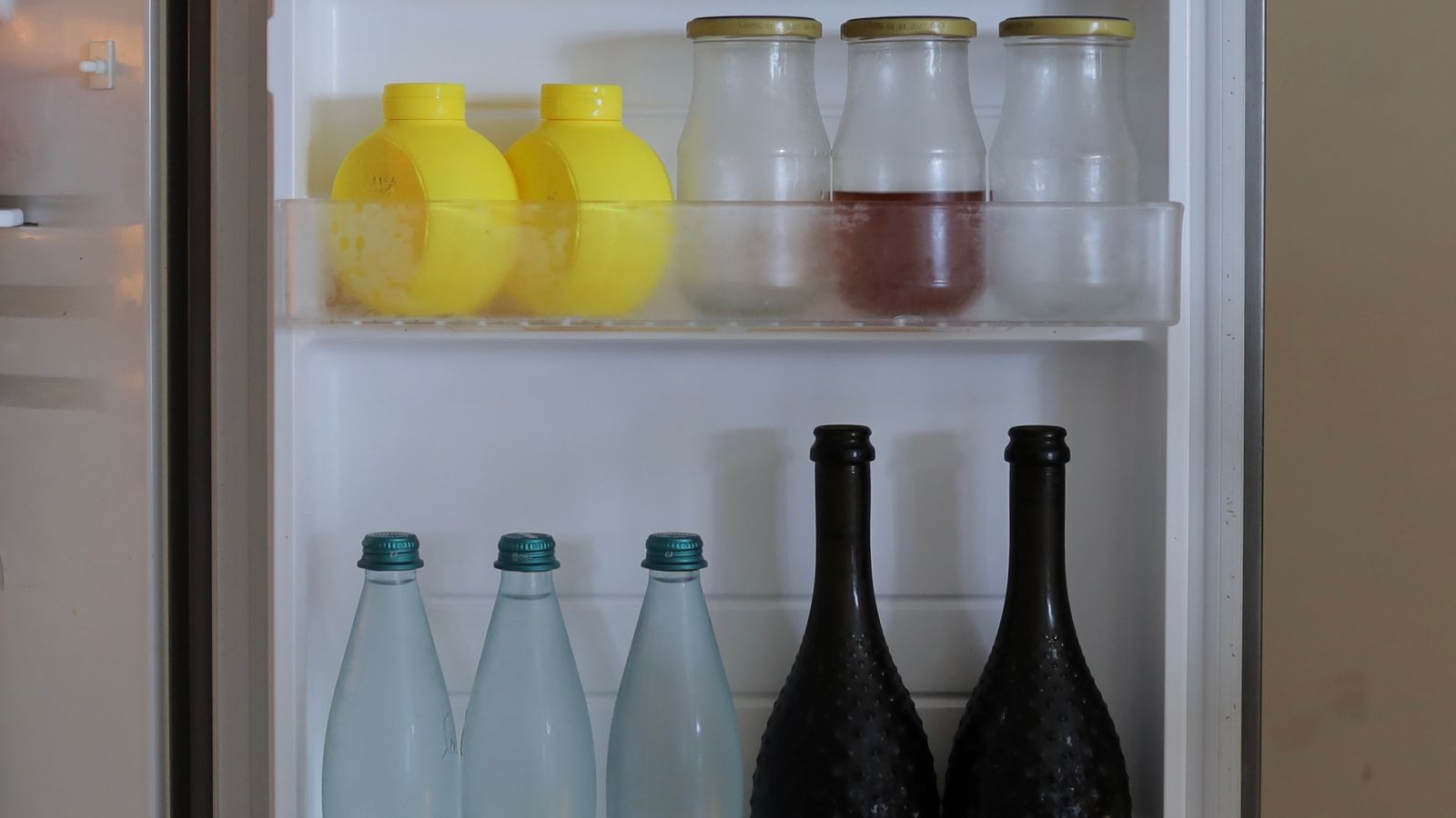 Organized refrigerator shelves with bottles and containers after setup