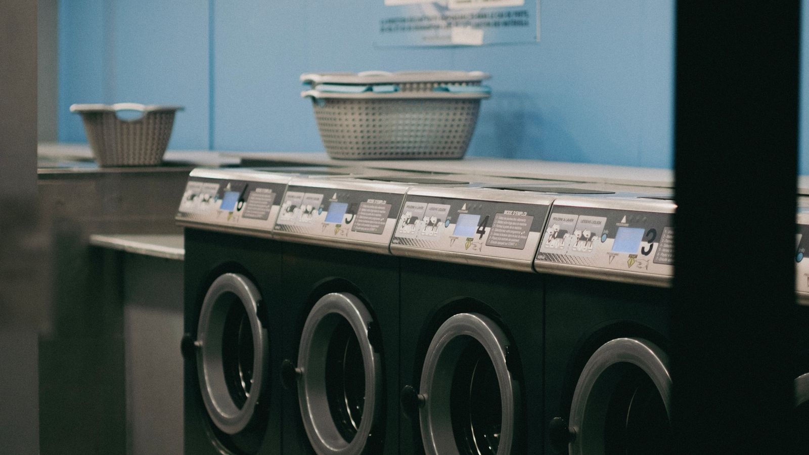 Laundry room rug and towels air drying on a rack near a washer and dryer