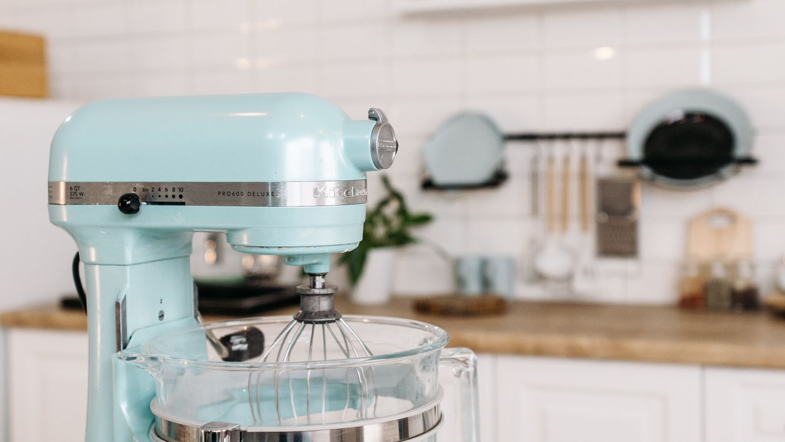 Stand mixer sitting on a kitchen counter with a fabric cover nearby
