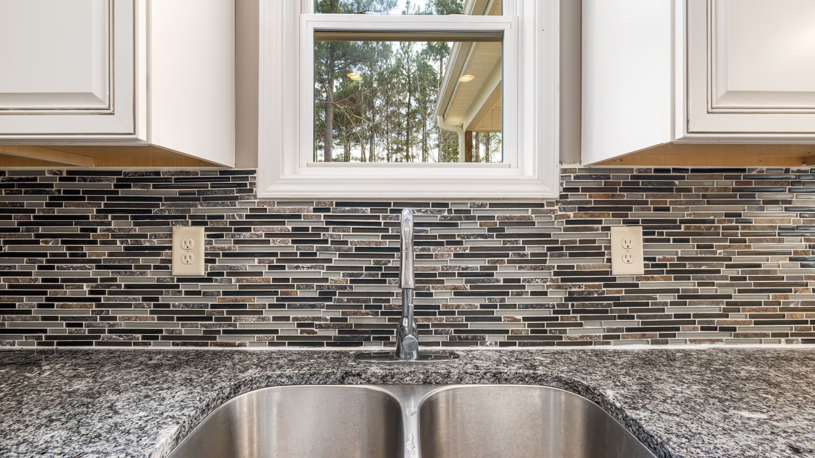 Close-up of a peel and stick backsplash tile installed behind a kitchen sink