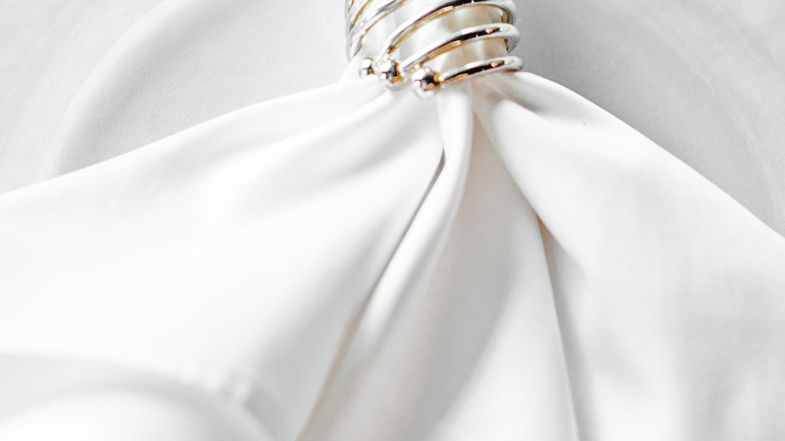 Elegant table setting with a folded napkin secured by a decorative napkin ring